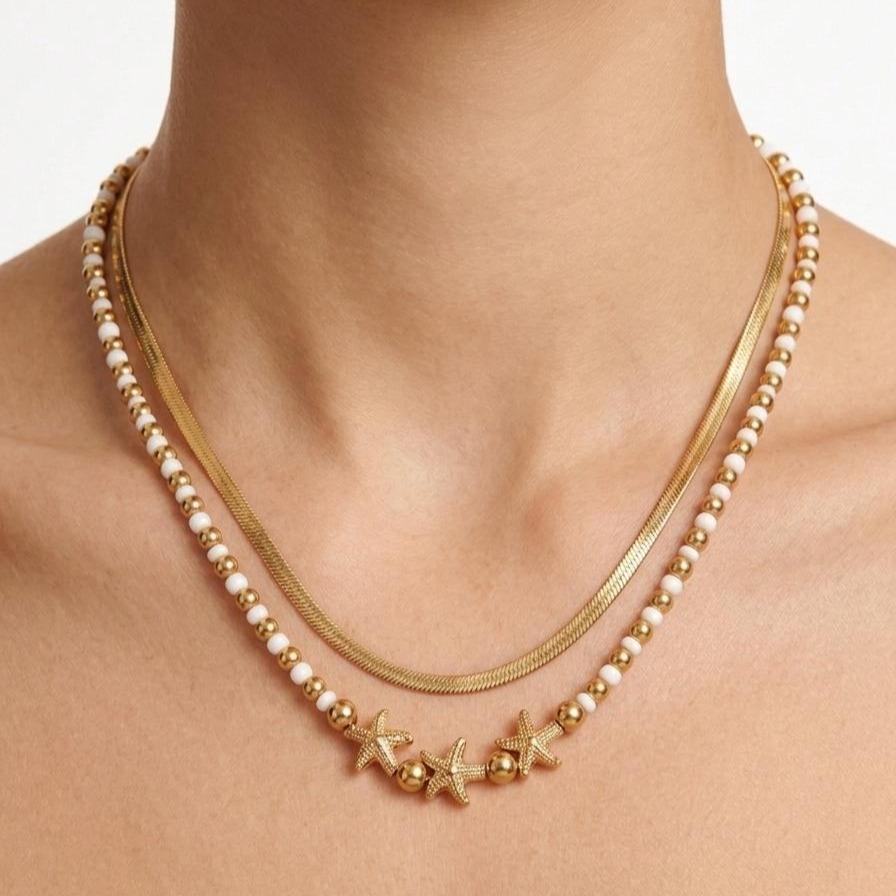 Collana Marea, un gioiello in acciaio studiato per chi cerca un accessorio dinamico e sofisticato. Grazie al suo design a doppio filo, offre un look stratificato già pronto, capace di illuminare il volto con un tocco dorato e colorato.