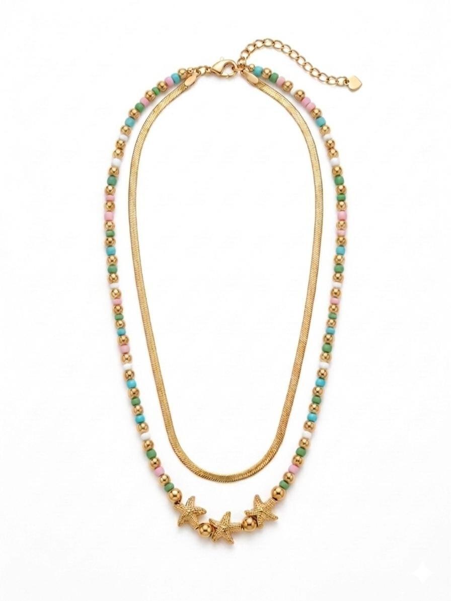 Collana Marea, un gioiello in acciaio studiato per chi cerca un accessorio dinamico e sofisticato. Grazie al suo design a doppio filo, offre un look stratificato già pronto, capace di illuminare il volto con un tocco dorato e colorato.