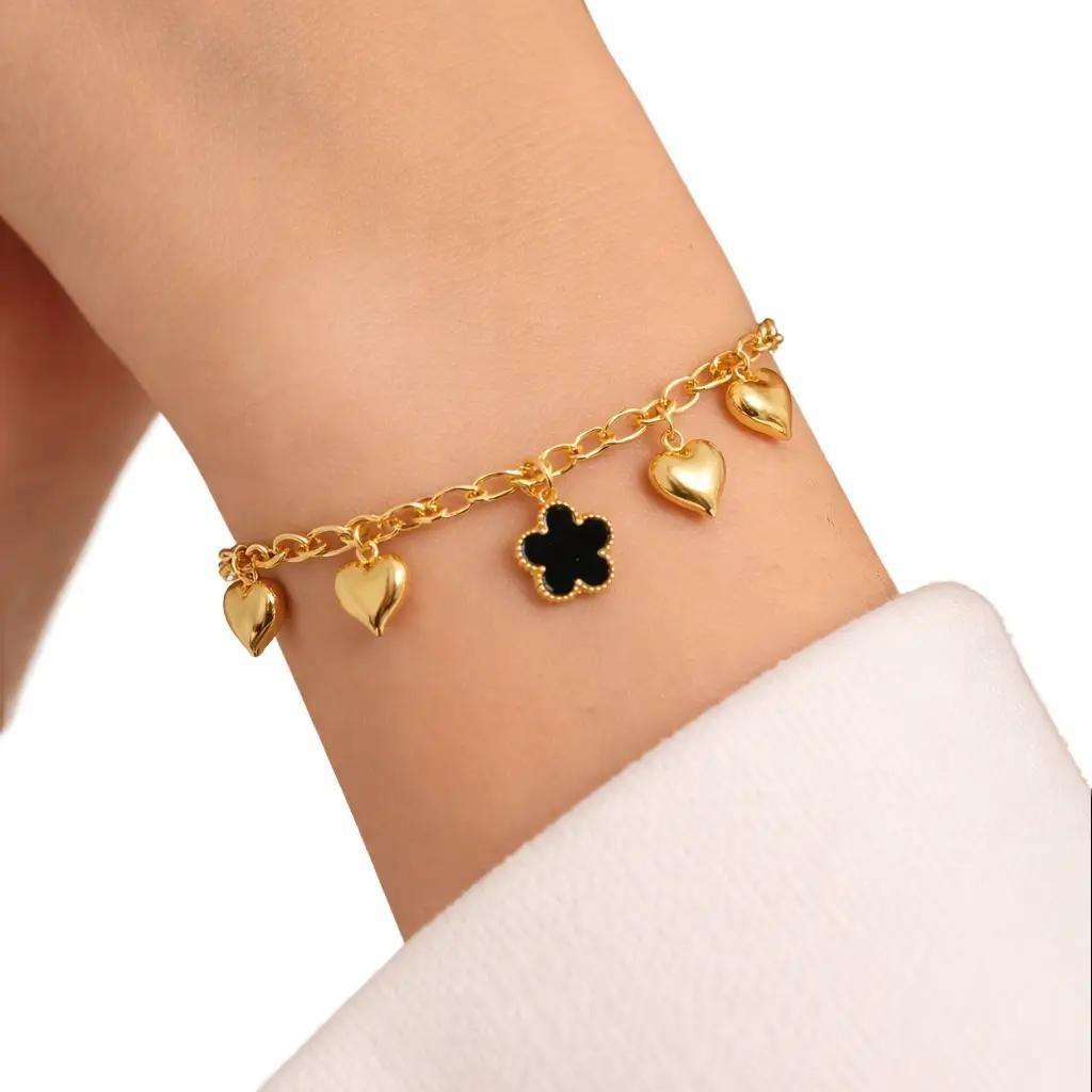 Bracciale Blossom in acciaio con elegante catena impreziosita da charms in ottone a forma di cuore e fiore. Il design delicato e luminoso dona un tocco romantico e raffinato